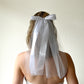 Model wearing white veil with satin bow